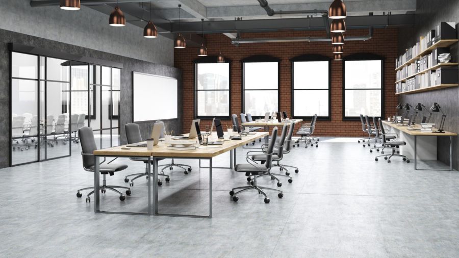 Modern office workspace with desks, chairs, and large windows in a clean commercial setting